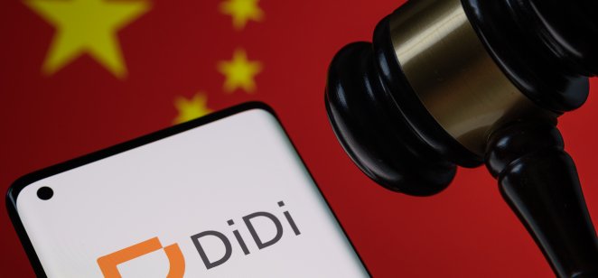 The company logo of Didi on a mobile phone next to a gavel and Chinese flag