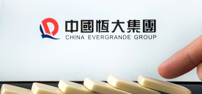 A logo of Evergrande with falling dominos in the foreground