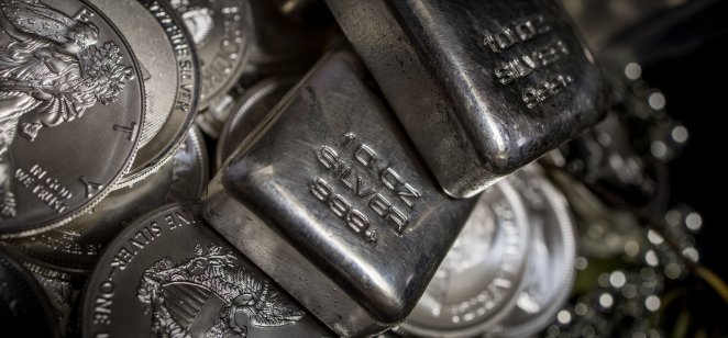 Silver bullion and coins on a dark background 