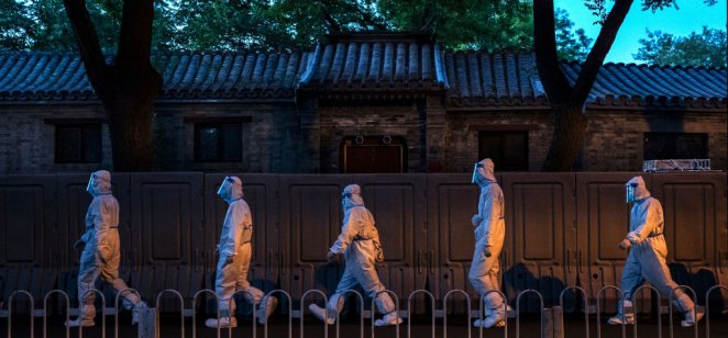 Health workers outside a community in Beijing that is locked down