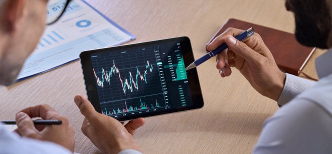People examine a trading chart on a tablet