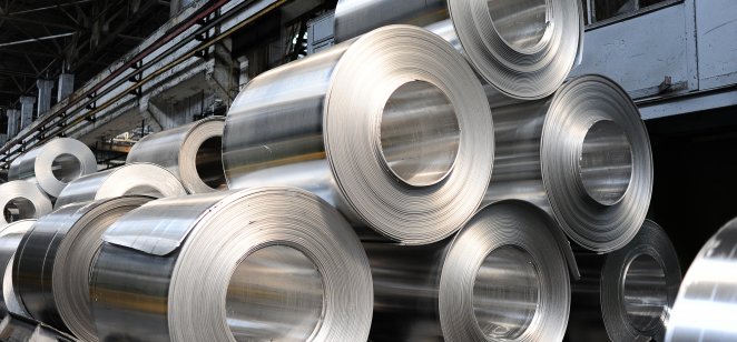 A stack of sheets of rolled aluminium in a factory