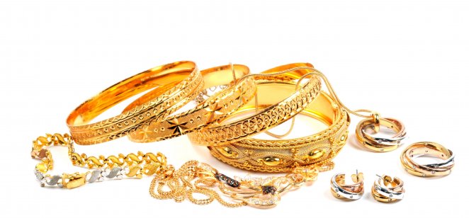 A pile of gold jewellery items on a white background