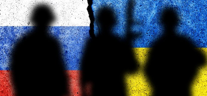 Russia and Ukraine flags on wall with soldiers' shadows