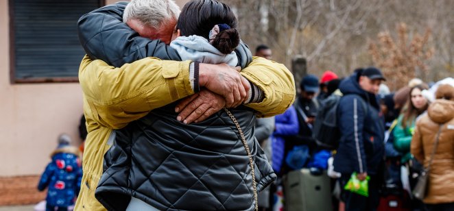 Ukrainian refugees hug each other