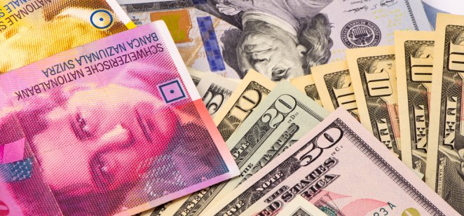 US dollars and Swiss franc banknotes