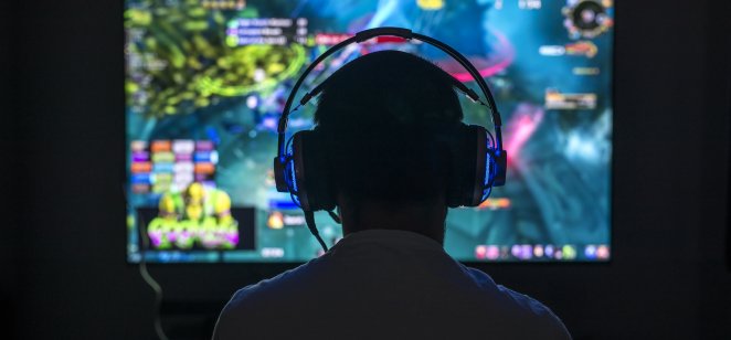 A gamer playing video game wearing headphones