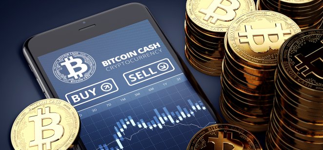 Jetons d'argent Bitcoin à côté d'un smartphone avec échange d'argent bitcoin