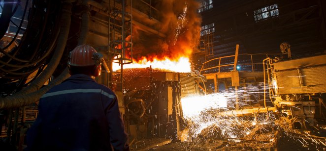 A worker watches steel making in a plant