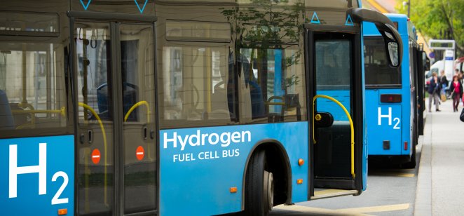 A hydrogen bus pulling up to pick up passengers