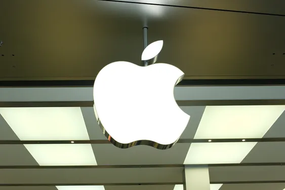 Apple logo illuminated on the exterior of a modern retail store