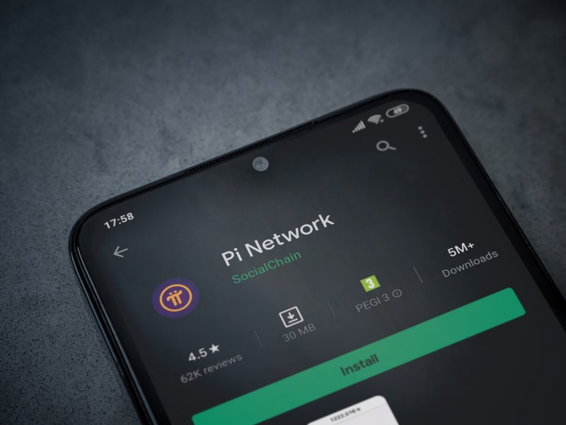 Pi Network app page Pi Network app play store page on the display of a black mobile smartphone on dark marble stone background. Top view flat lay with copy space.