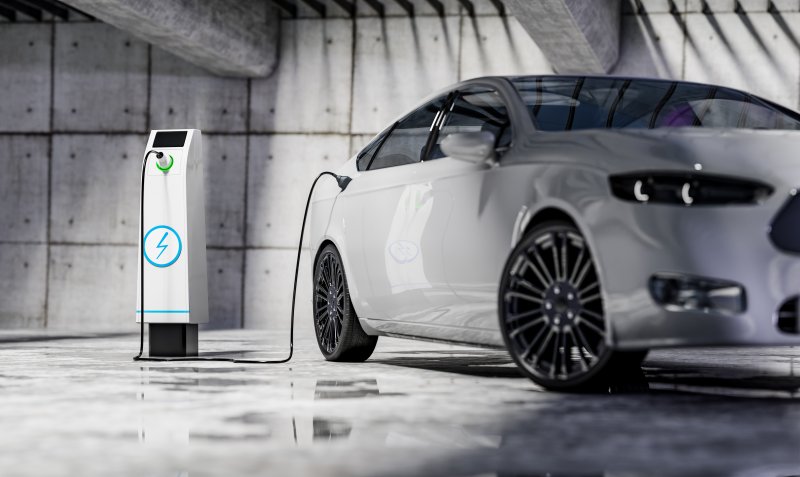 biggest electric vehicle companies Charging an electric car with a public charger in a parking lot sustainable climate visuals
