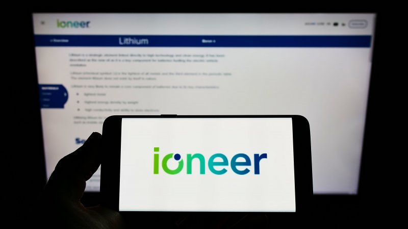 Ioneer stock forecast Person holding mobile phone with logo of Australian mining company company ioneer Ltd on screen in front of web page Focus on phone display