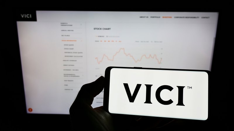 VICI Properties shareholders Person holding cellphone with logo of US real estate company Vici Properties Inc. on screen in front of business webpage. Focus on phone display