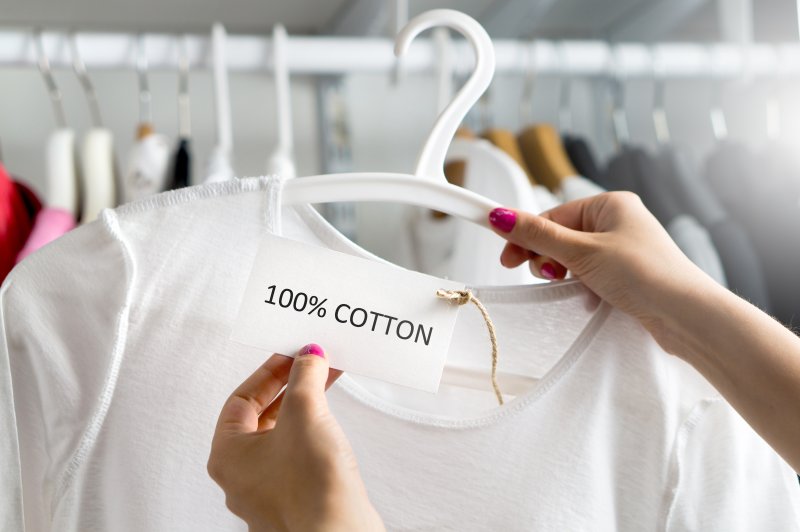 Cotton Cotton clothing on a rail being examined by a shopper