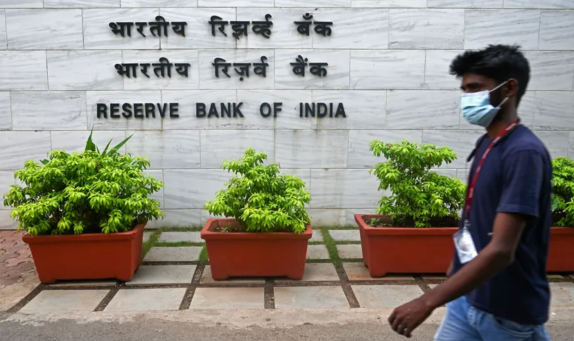 A pedestrian walks past the entrance of the Reserve Bank of India (RBI) headquarters in Mumbai