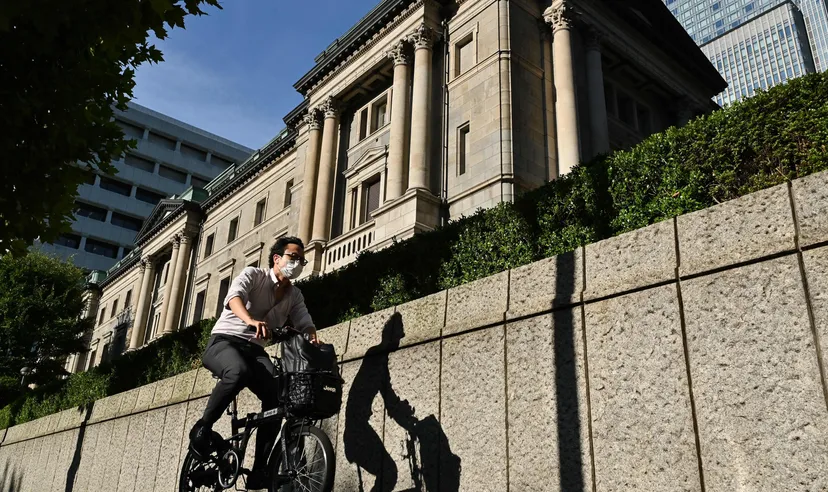 A man bicycles past the Bank of Japan headquarters buildings in Tokyo