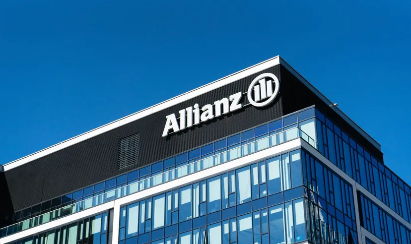 Modern glass office building with the Allianz logo displayed on the top facade against a clear blue sky Modern glass office building with the Allianz logo displayed on the top facade against a clear blue sky