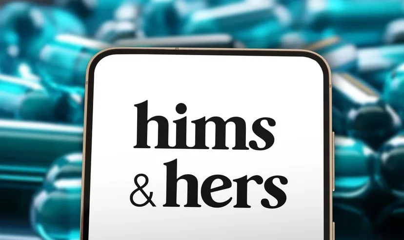 Smartphone displaying the Hims & Hers logo in front of blurred prescription capsules, representing the digital healthcare and telemedicine company.