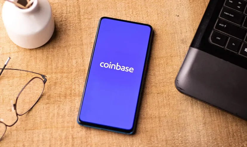 Application Coinbase affichée sur un smartphone posé sur un bureau