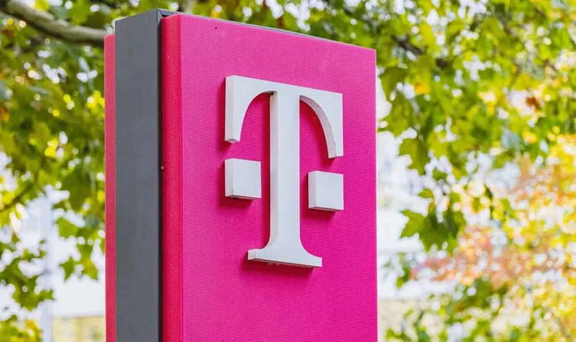 Deutsche Telekom Logo auf einem pinken Schild im Freien mit grünen Bäumen im Hintergrund