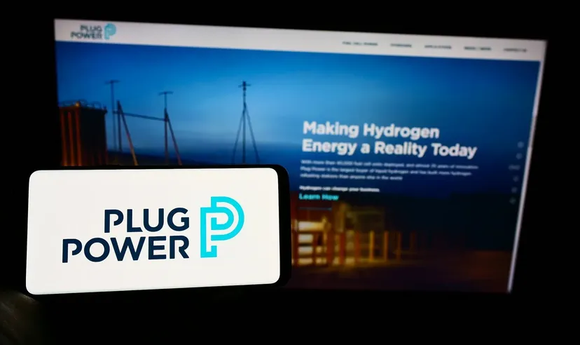 Plug Power Logo auf einem mobilen Gerät mit der Unternehmenswebsite über Wasserstoffenergie im Hintergrund