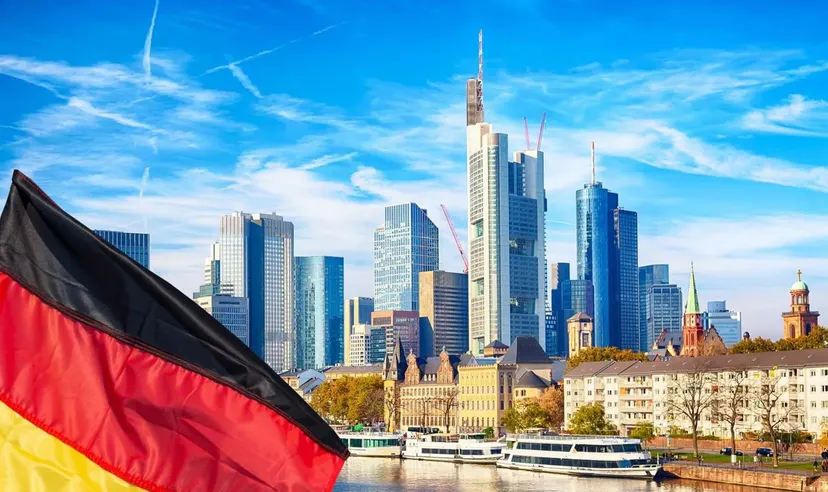 Frankfurter Skyline mit modernen Wolkenkratzern des Finanzviertels und deutscher Flagge, repräsentiert den Germany 40 (DAX) Index