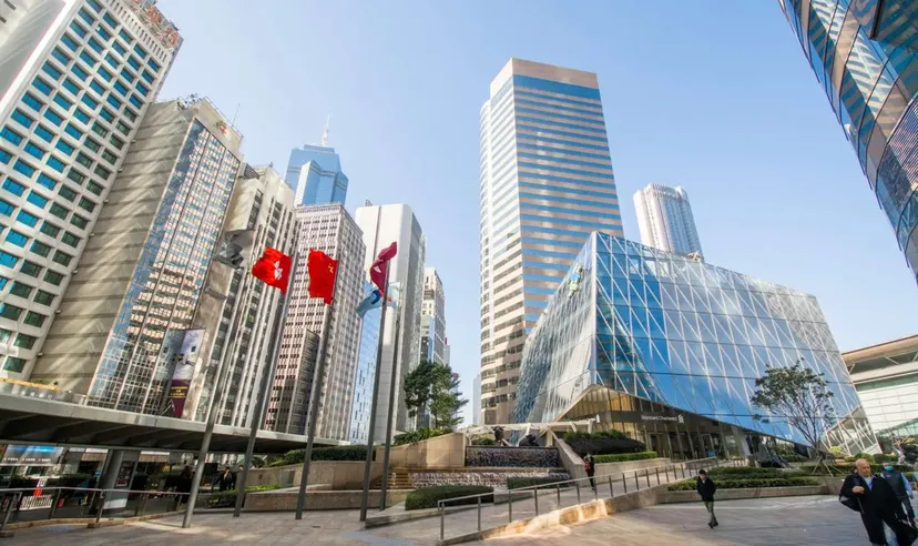 Skyline del distretto finanziario di Hong Kong con moderne torri per uffici e bandiere vicino a Exchange Square