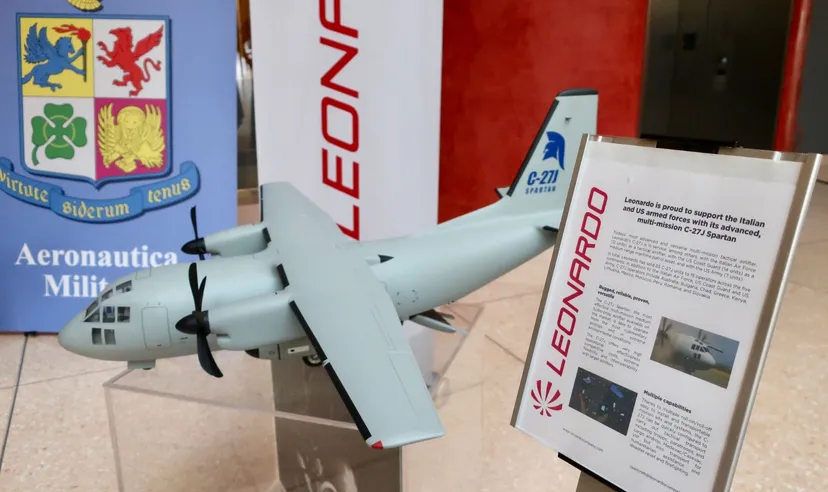 Modello di aereo militare esposto accanto al logo Leonardo durante una presentazione nel settore della difesa e aerospazio