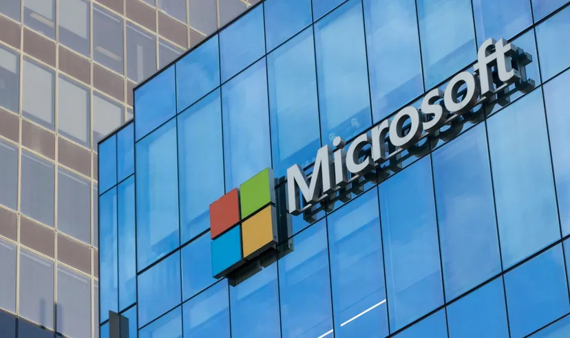 Microsoft logo on the facade of a modern glass office building