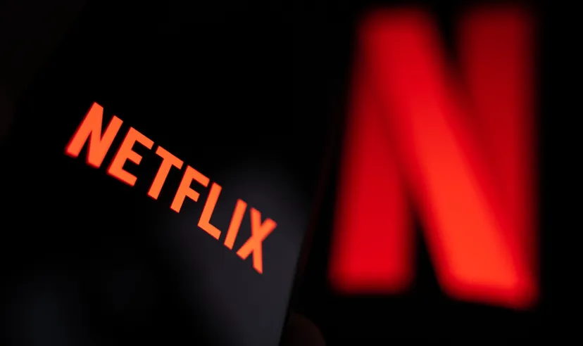 Smartphone displaying the Netflix logo with the streaming platform's iconic red “N” blurred in the background, representing the global entertainment and streaming service.