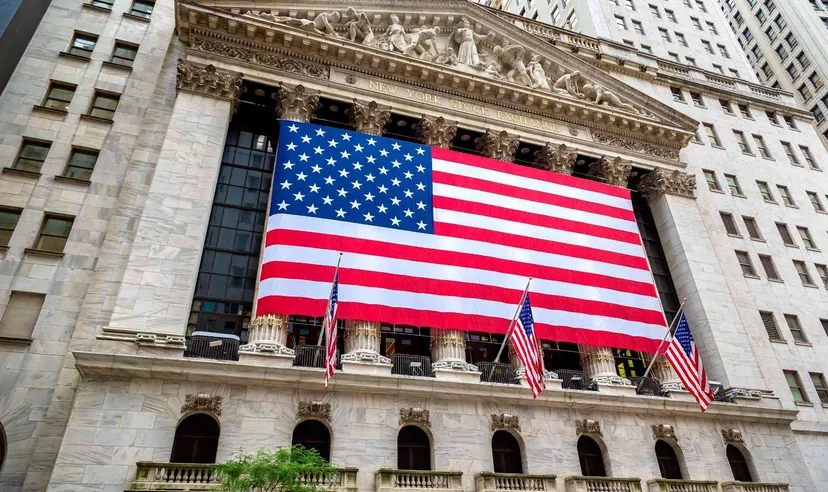 Facciata della Borsa di New York (NYSE) con una grande bandiera americana esposta sulla parte frontale dell’edificio Facciata della Borsa di New York (NYSE) con una grande bandiera americana esposta sulla parte frontale dell’edificio