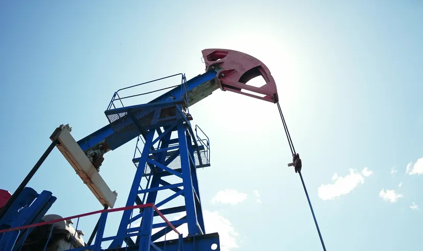 Ölpumpe (Pumpjack) fördert Rohöl unter blauem Himmel – Symbol für Energieproduktion und Ölmarkt. Ölpumpe (Pumpjack) fördert Rohöl unter blauem Himmel – Symbol für Energieproduktion und Ölmarkt.