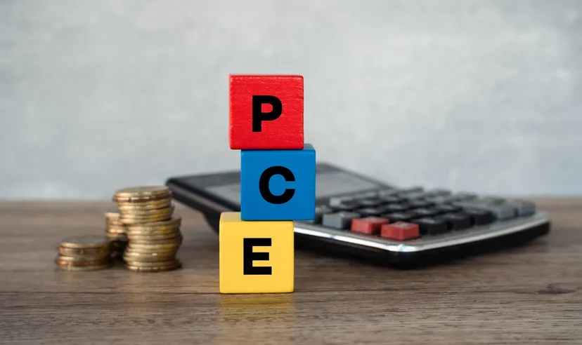 PCE inflation blocks with calculator and coins Stacked wooden blocks spelling “PCE” beside a calculator and coins, illustrating the US Personal Consumption Expenditures inflation index.