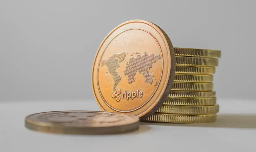 Moneta kryptowaluty Ripple umieszczona przed stosem monet