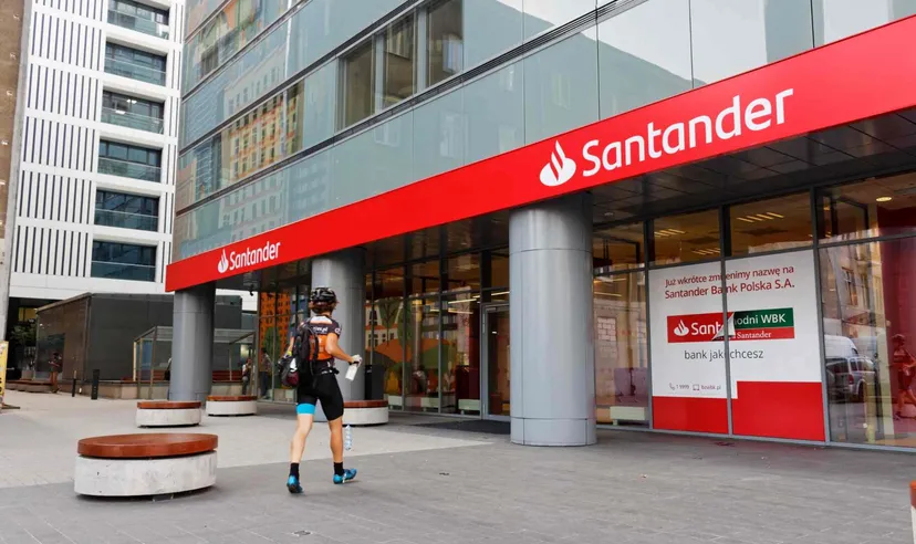 Exterior of a Santander bank branch displaying the company logo on a modern office building, representing the international banking and financial services group. 