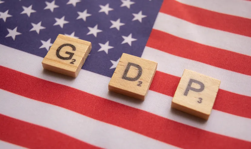 Finance Concept, GDP or Gross domestic product wooden block letters on US Dollar flag