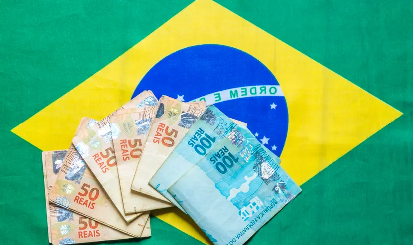 Brazilian currency on top of the national flag