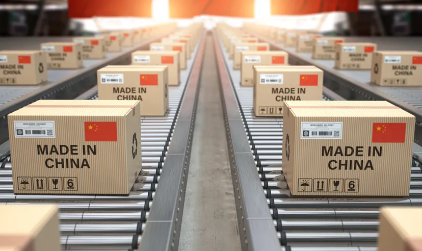 Cardboard boxes with Chinese-made text and a Chinese flag on a roller conveyor.