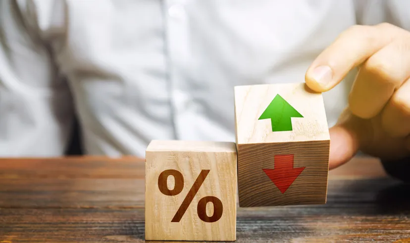 A businessman holds wooden blocks with percentages and up or down arrows. Mortgage and loan rates. Interest rate, shares, rating. The concept of business and finance.