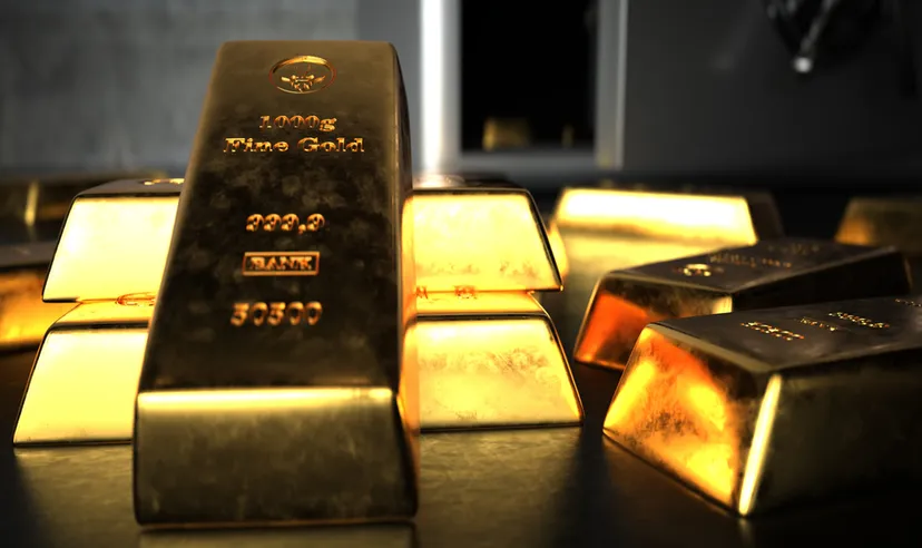 Fine gold bars in front of an open safe.