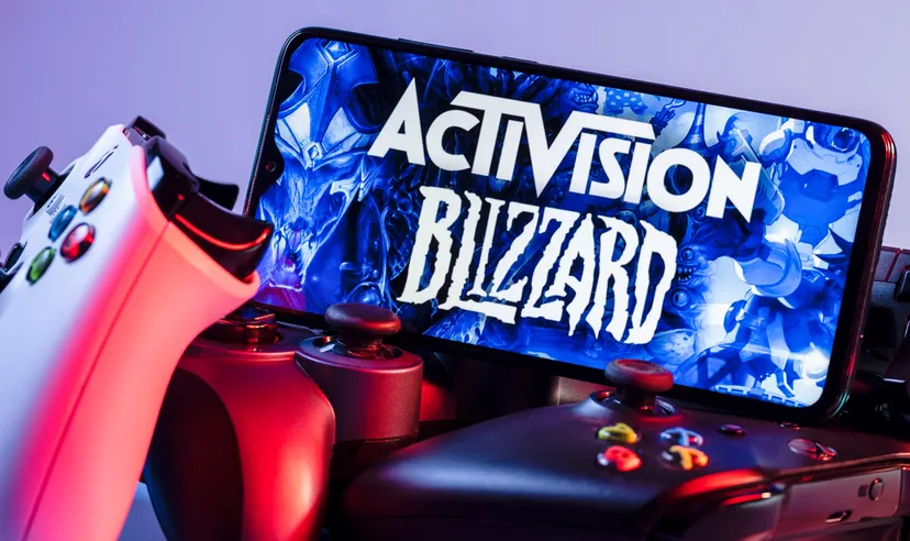 Activision Blizzard gaming Smartphone with Activision Blizzard logo on the screen on top of game consoles