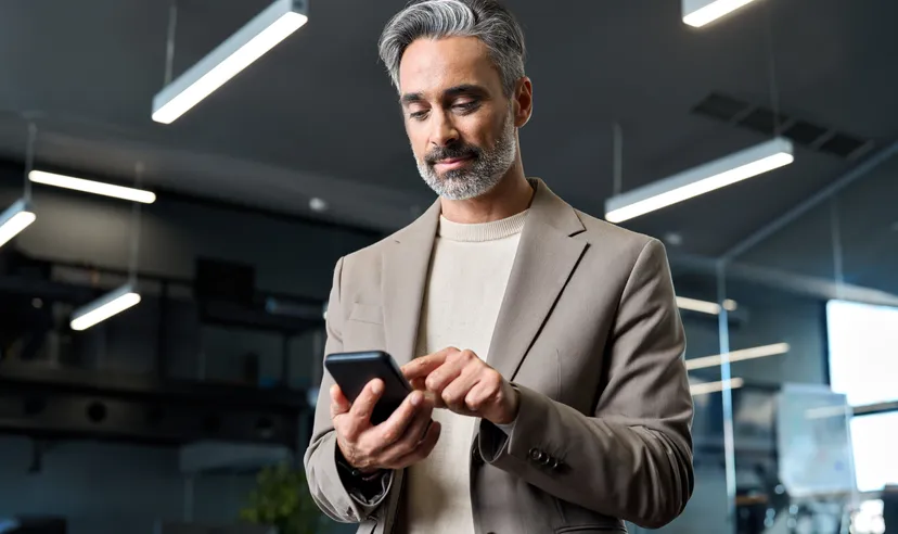 Man using a smartphone in a modern office.