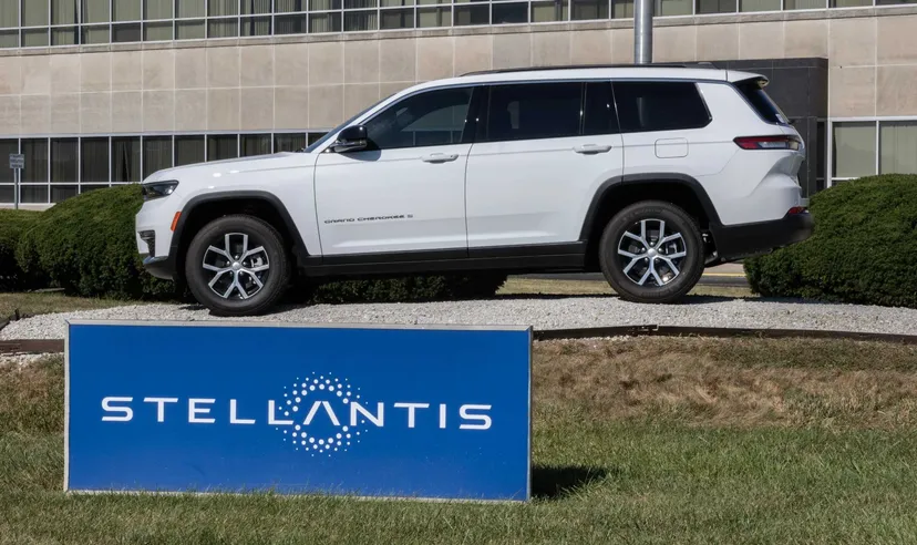 Jeep Grand Cherokee SUV bianco davanti alla sede Stellantis con logo aziendale visibile