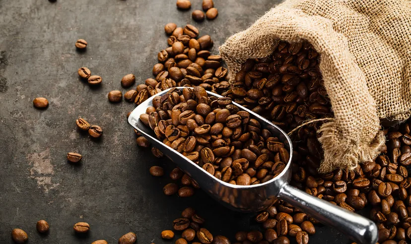 Coffee beans falling out of bag with scoop