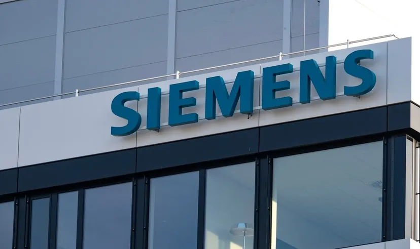 Siemens-Logo an der Außenfassade eines modernen Bürogebäudes mit Glasfenstern
