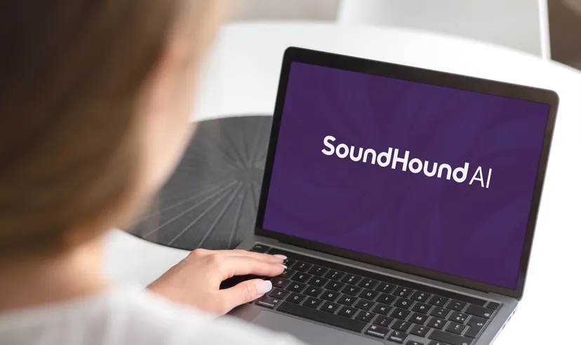 Person using a laptop displaying the SoundHound AI logo on the screen