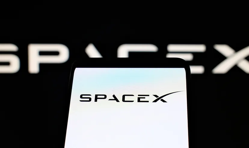 Logo SpaceX visualizzato sullo schermo di uno smartphone con sfondo nero e marchio sfocato sul retro