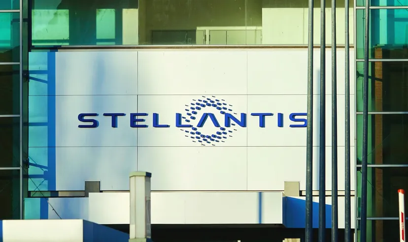 Logo Stellantis esposto sulla parete esterna di un edificio per uffici moderno con facciata in vetro.